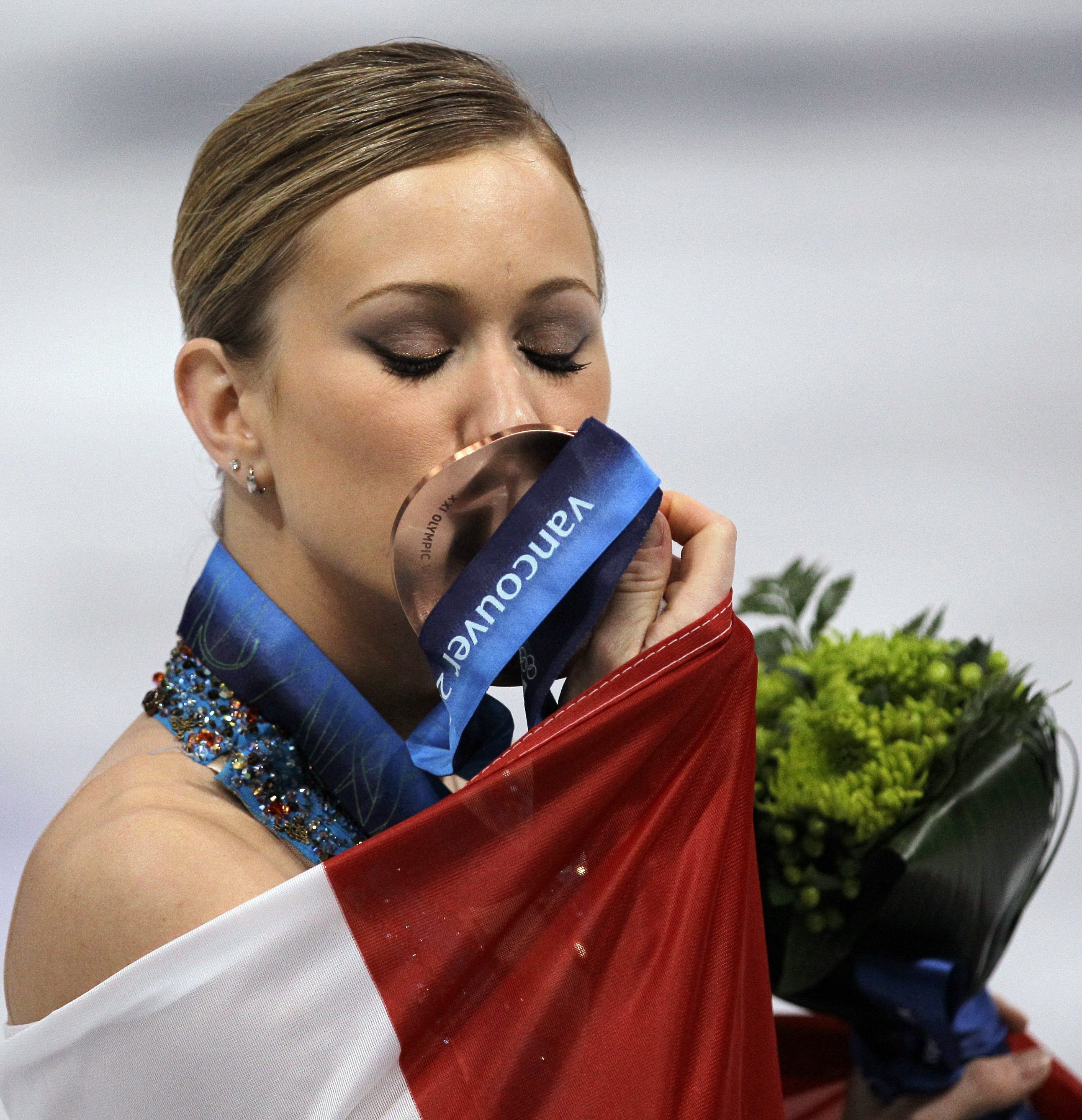 Joannie Rochette kisses her bronze medal during the victory celebration at the Vancouver 2010 Olympics