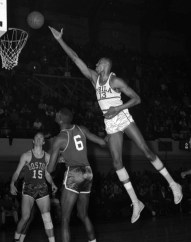 Wilt Chamberlain shoots over Boston defenders in Philadelphia, 1960. (AP Photo/files)