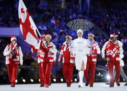 Nino Tsiklauri of Georgia carries her country flag as the team arrives during the opening ceremony of the 2014 Olympic Winter Games in Sochi, Russia, Friday, Feb. 7, 2014. (AP Photo/Matt Dunham)