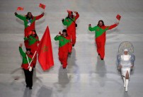 Adam Lamhamedi of Morocco holds his national flag and enters the arena with teammates during the opening ceremony of the 2014 Olympic Winter Games in Sochi, Russia, Friday, Feb. 7, 2014. (AP Photo/Charlie Riedel)
