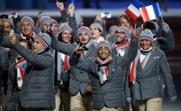 Figure skater Florent Amodio of France, foreground right, gestures as he arrives during the opening ceremony of the 2014 Olympic Winter Games in Sochi, Russia, Friday, Feb. 7, 2014. (AP Photo/Mark Humphrey)