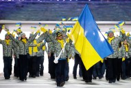 Valentina Shevchenko of Ukraine carries the national flag as she leads the team during the opening ceremony of the 2014 Olympic Winter Games in Sochi, Russia, Friday, Feb. 7, 2014. (AP Photo/Mark Humphrey)