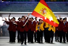 Javier Fernandez of Spain carries the national flag as he leads the team as they arrive during the opening ceremony of the 2014 Olympic Winter Games in Sochi, Russia, Friday, Feb. 7, 2014. (AP Photo/Mark Humphrey)