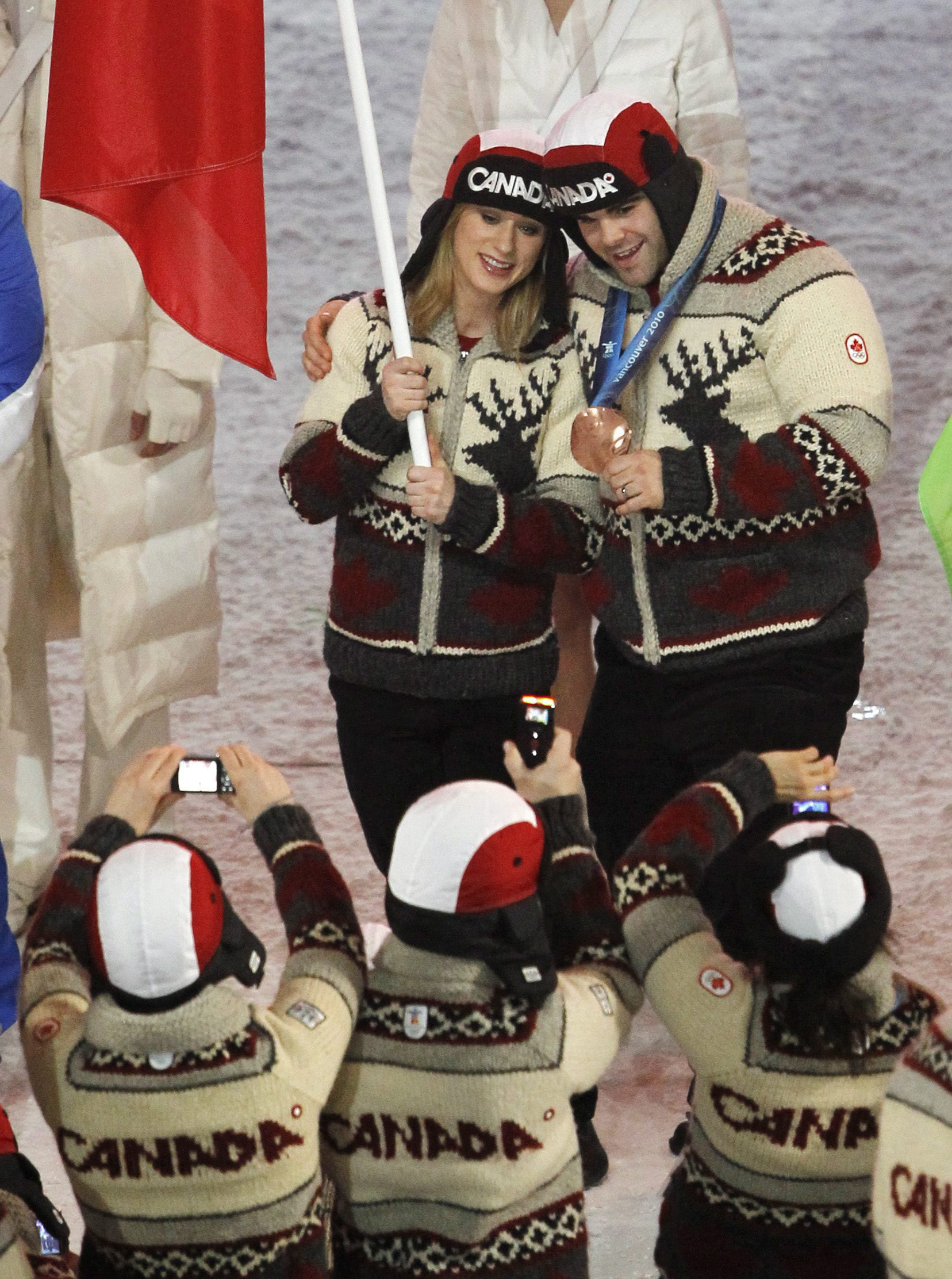 Bobsleigh bronze medalist David Bissett has his photo taken with Canadian flag bearer women's figure skating bronze medalists Joannie Rochette during the 2010 Vancouver Olympic Winter Games closing ceremonies on Sunday, Feb. 28, 2010 at B.C. Place in Vancouver. THE CANADIAN PRESS/Nathan Denette