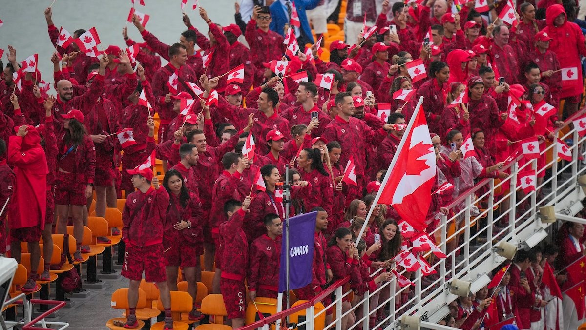 Team Canada athletes all dressed in red on the top deck of a boat during the Paris 2024 Opening Ceremony