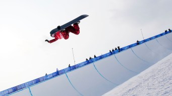 Elizabeth Hosking grabs her board as she does a flip above the halfpipe