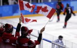 Fans wave flags during the third period of the preliminary round of the women's hockey game between Canada and Finland at the 2018 Winter Olympics in Gangneung, South Korea, Tuesday, Feb. 13, 2018. (AP Photo/Frank Franklin II)