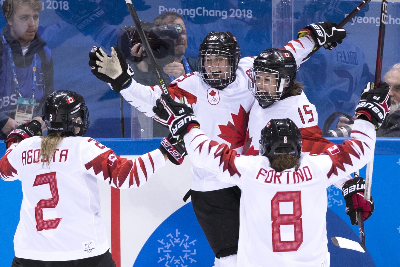 Canadian women celebrate a hockey goal 