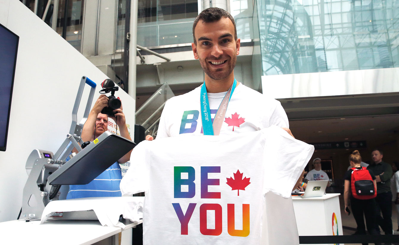 Eric Radford holding Be You t-shirt