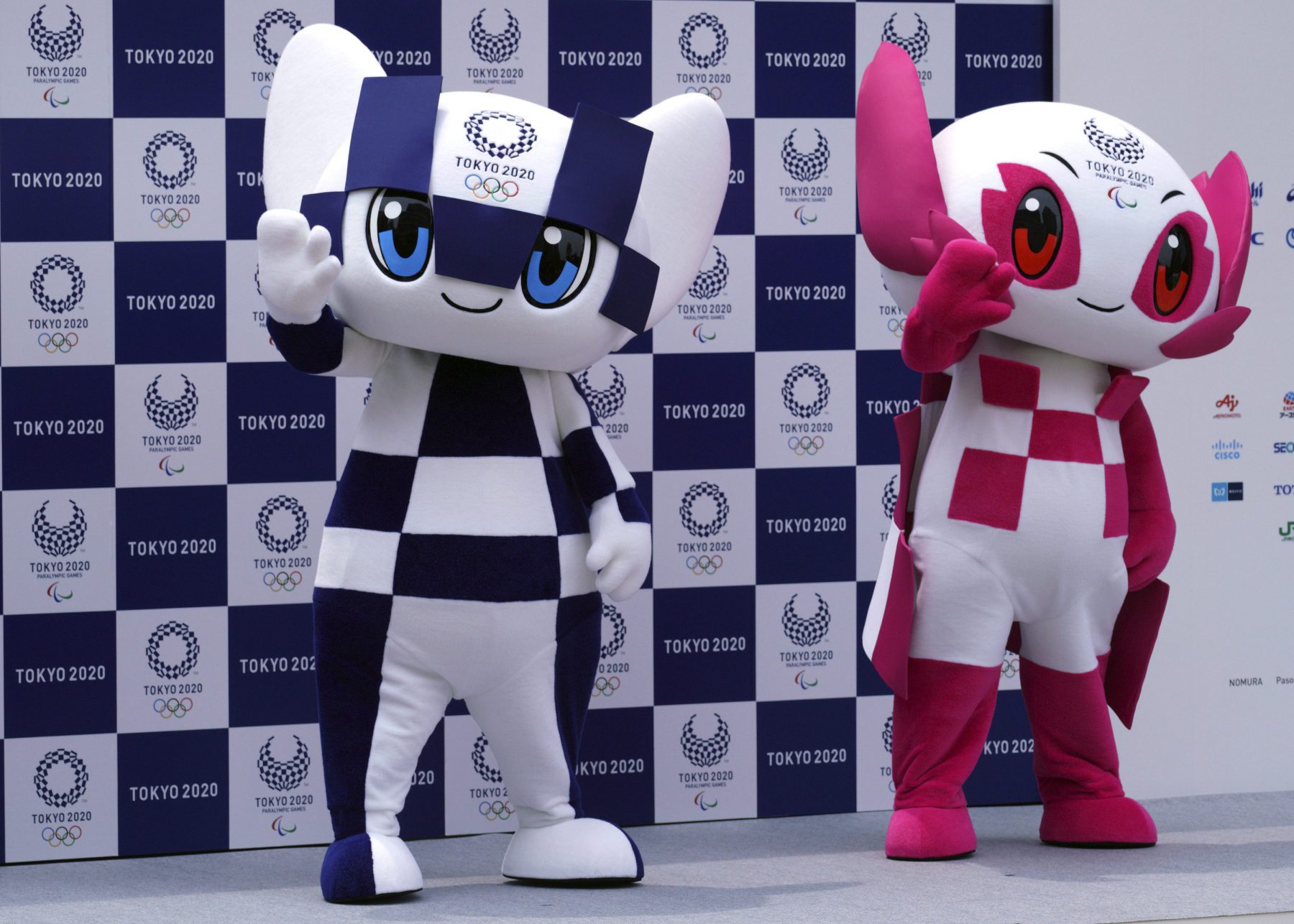 Tokyo 2020 Olympic mascot "Miraitowa", left, and Paralympic mascot "Someity", right, pose for photographers during the mascot debut event in Tokyo Sunday, July 22, 2018. The official mascots for the Tokyo 2020 Olympics and Paralympics were unveiled at a ceremony on Sunday. The two mascot designs were selected by elementary schoolchildren across Japan. (AP Photo/Eugene Hoshiko)