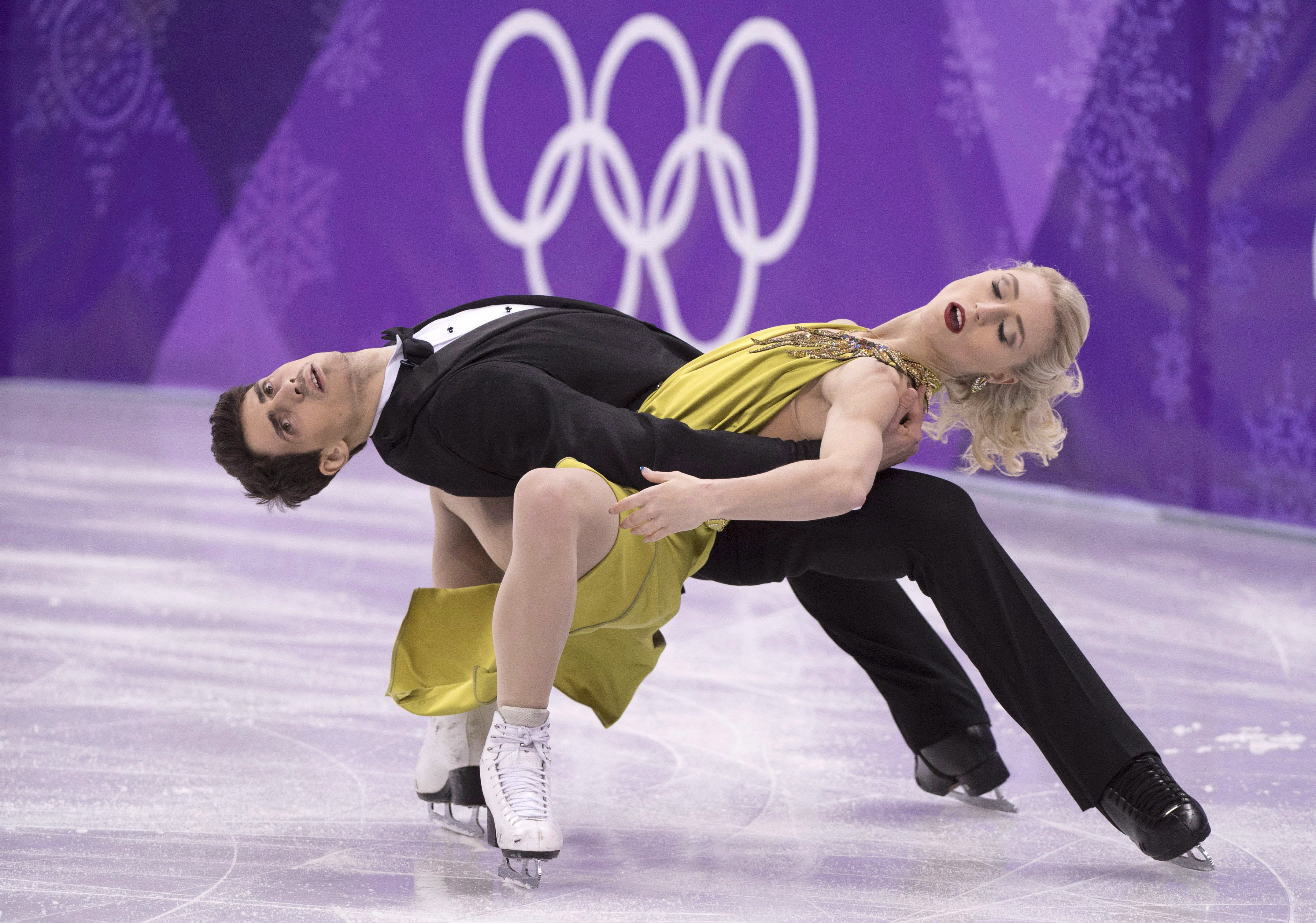 Two figure skaters in a low to the ice move 