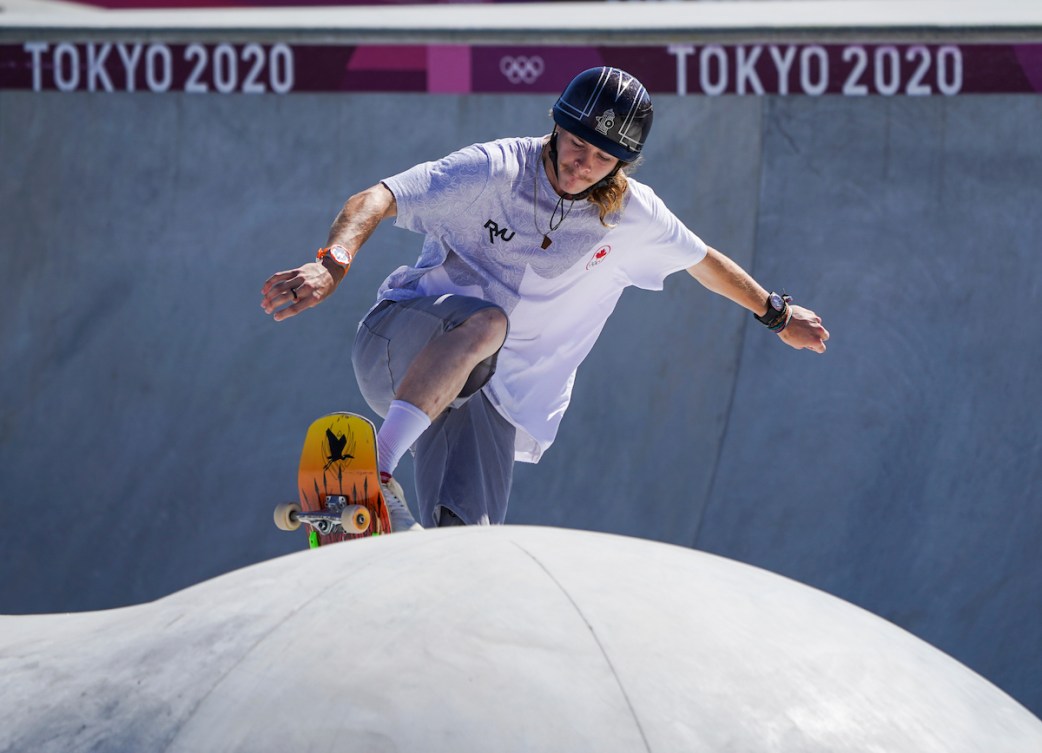 Andy Anderson rides his skateboard up over a bump in park competition 