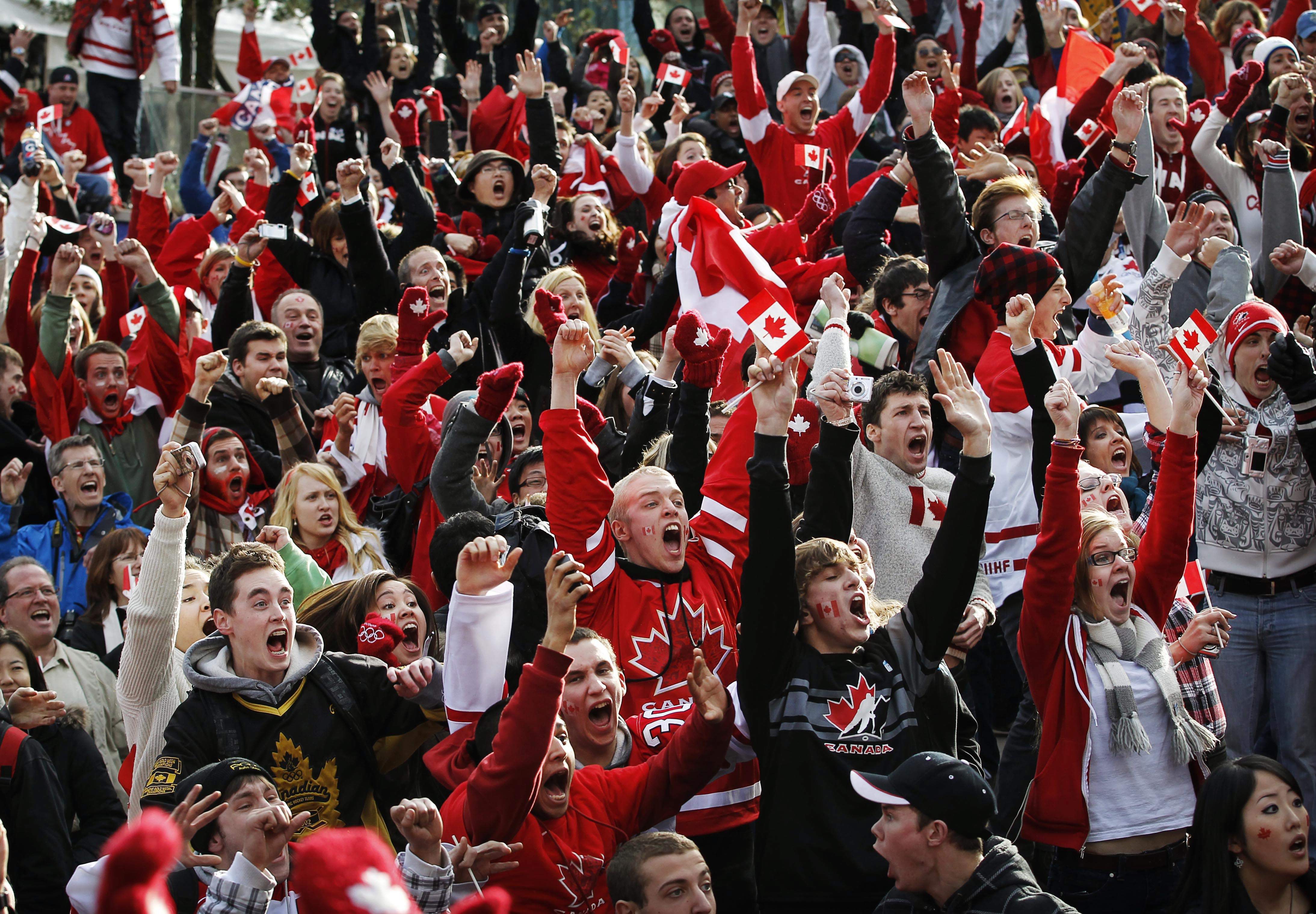 Canadian fans celebrate as Team Canada score in overtime in their gold medal victory against the United States in the final hockey match at the Vancouver 2010 Olympics, while watching the game on a giant display in downtown Vancouver, British Columbia, Sunday, Feb. 28, 2010. (AP Photo/Kevin Frayer)