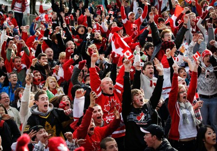 Canadian fans celebrate as Team Canada score in overtime in their gold medal victory against the United States in the final hockey match at the Vancouver 2010 Olympics, while watching the game on a giant display in downtown Vancouver, British Columbia, Sunday, Feb. 28, 2010. (AP Photo/Kevin Frayer)