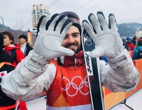 Skier holds up gloves to camera
