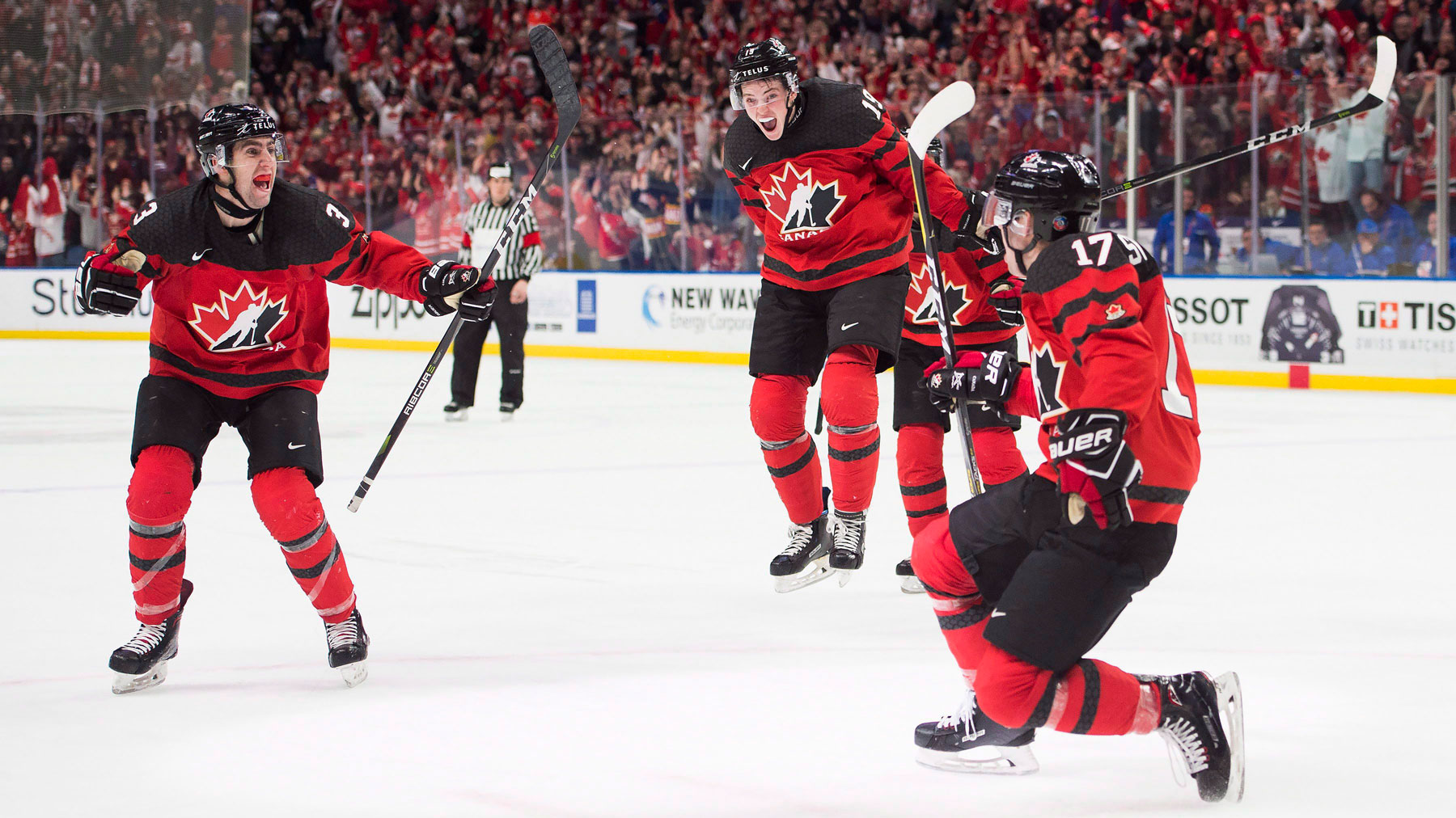 Trois joueurs célèbrent un but lors d'un match de hockey sur glace.