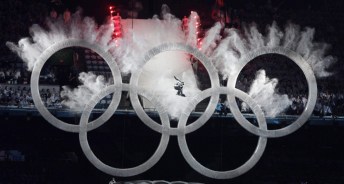 A snowboarder sailing through the Olympic rings during the opening ceremonies of Vancouver 2010