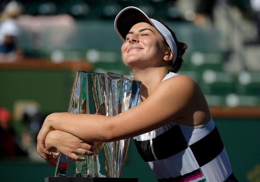 Bianca Andreescu, of Canada, smiles as she hugs her trophy