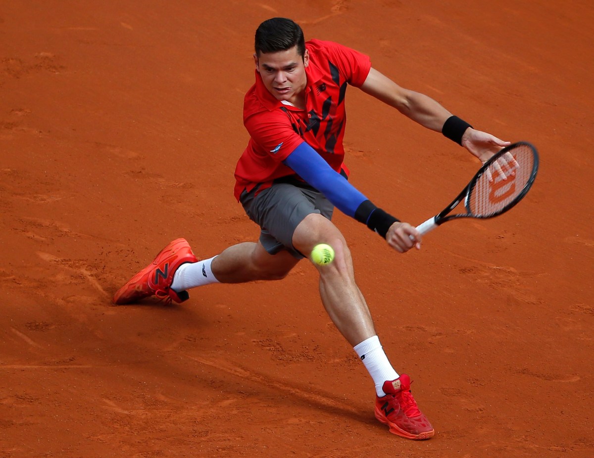 Milos Raonic backhands the ball
