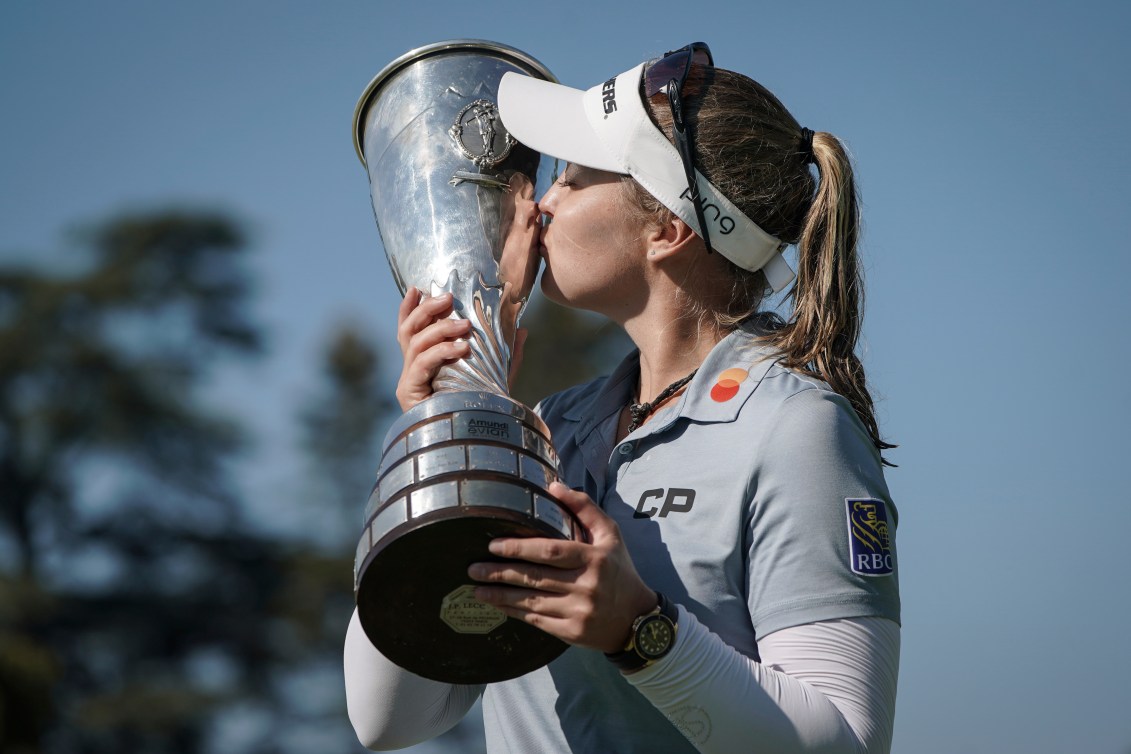 Brooke Henderson kisses a big silver trophy 