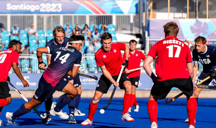 A group of field hockey players fight for the ball