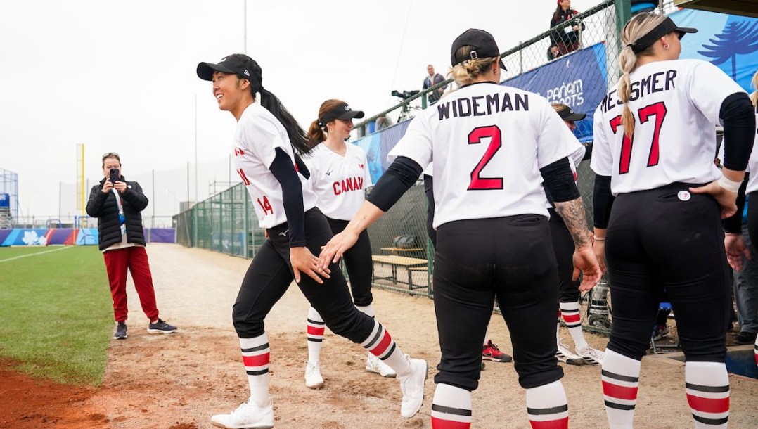 Janet Leung runs out of the dugout while high fiving her teammates