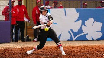 Softball player swings at the ball