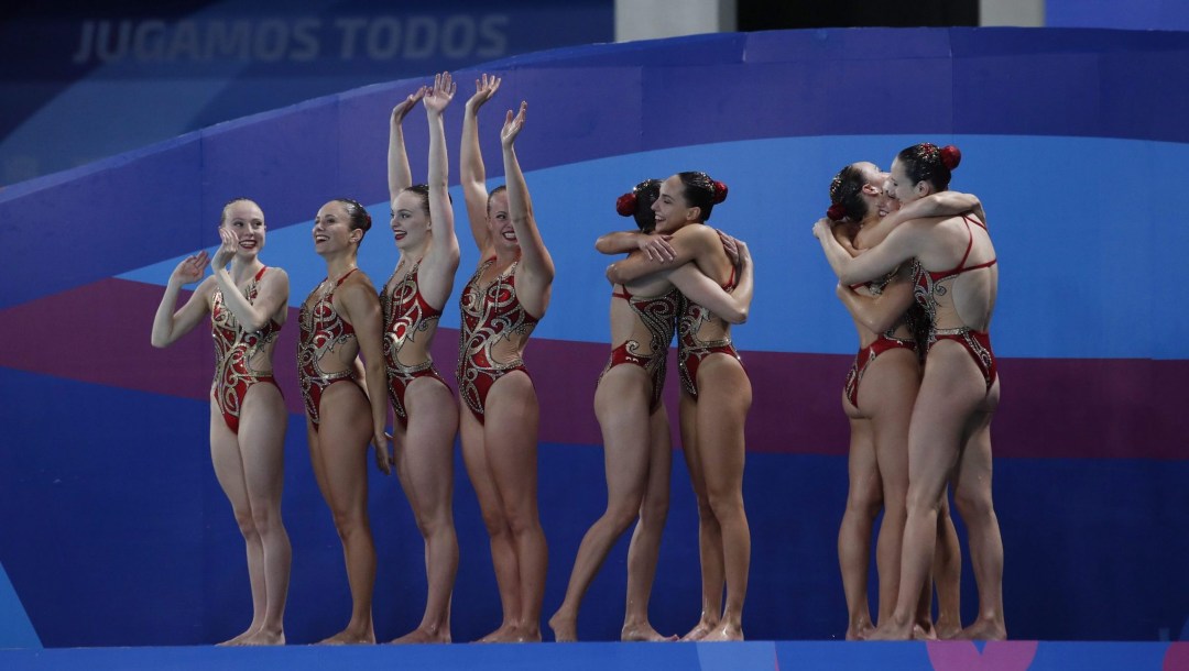 Emily Armstrong, Andree-Anne Cote, Camille Fiola-Dion, Rebecca Harrower, Claudia Holzner, Audrey Joly, Halle Pratt, Jacqueline Simoneau and Catherine Barrett, of Canada, embrace after competing in the artistic swimming team free routing final at the Pan American Games in Lima, Peru, Wednesday, July 31, 2019.