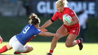 Rugby player running with ball and avoiding tackle