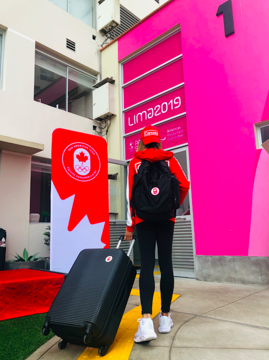 Athlete showing off her new jacket, suitcase, backpack and hat.