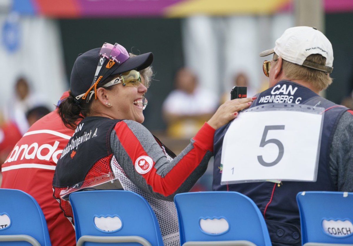 Amanda Chudoba pats Curtis Wennberg back happily during trap shooting