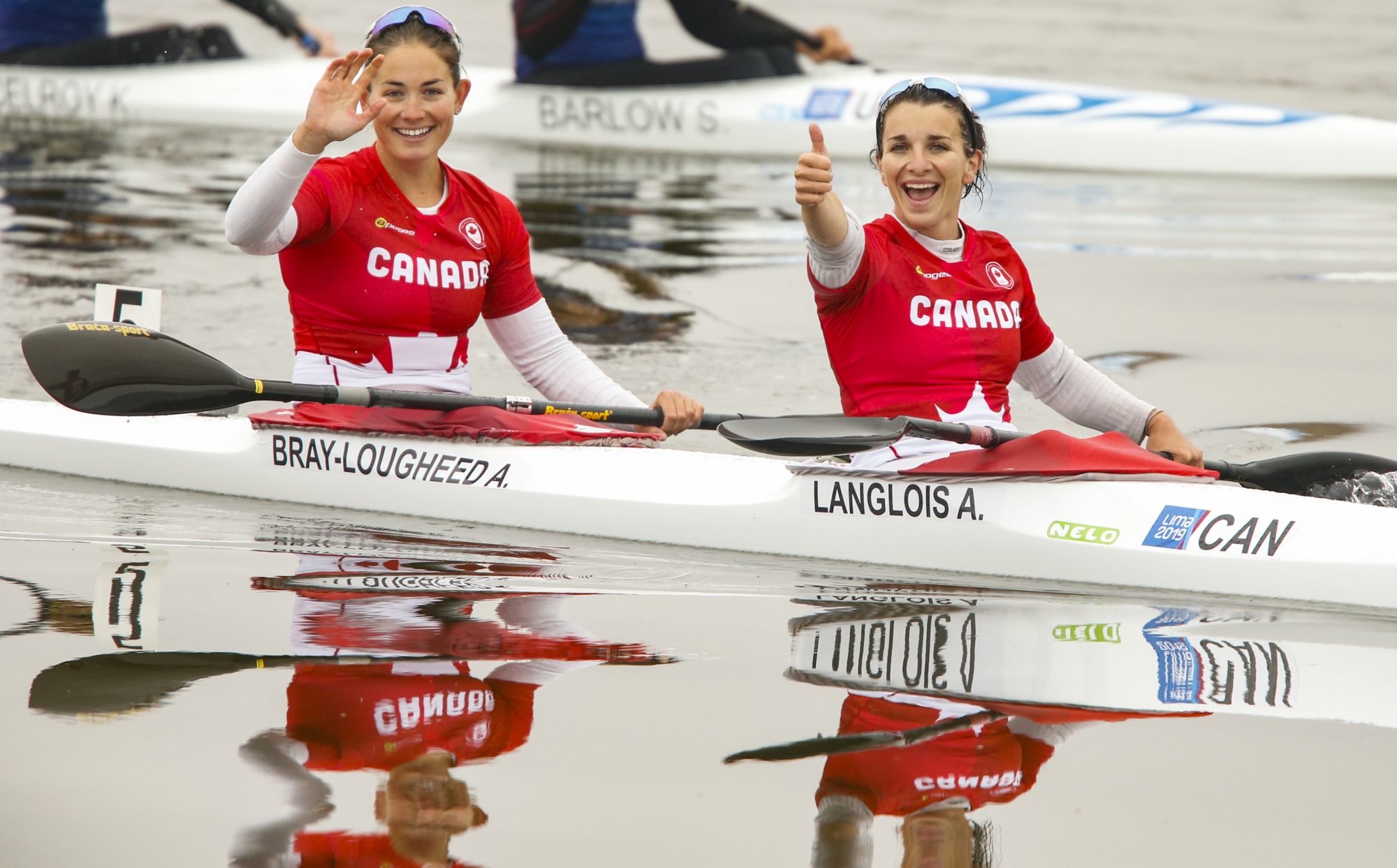 Two kayakers wave to the camera