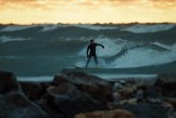 Surfer at sunset riding a wave
