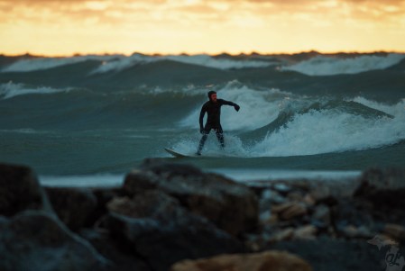 Surfer at sunset riding a wave