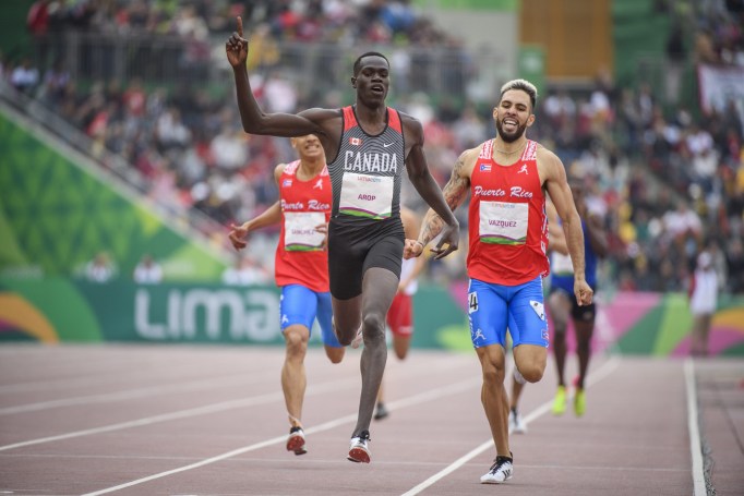 arop crosses the finish line with one arm up