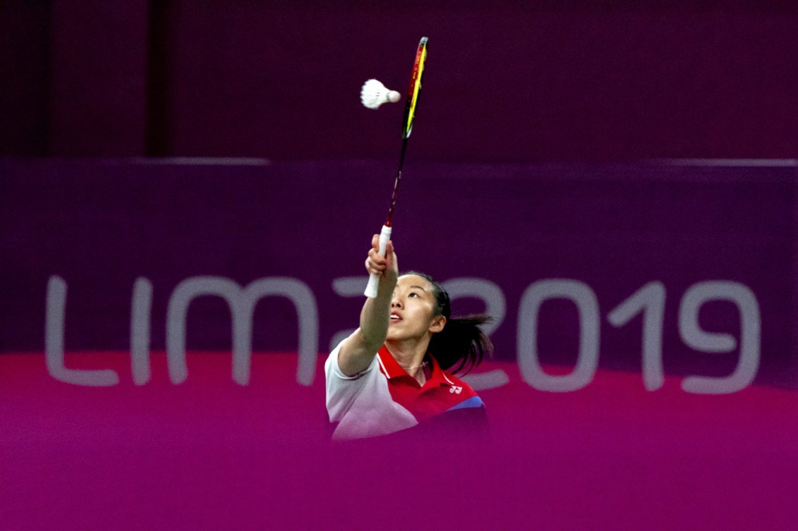 badminton player reaches for the birdie