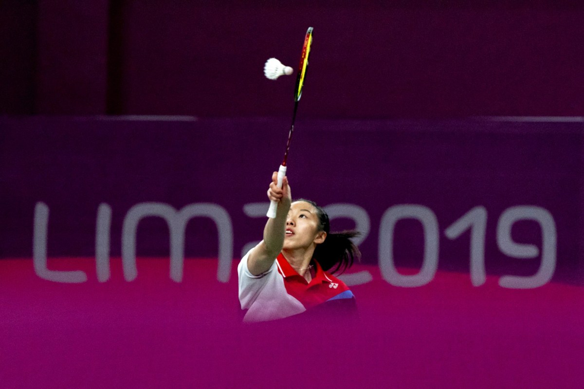 badminton player reaches for the birdie