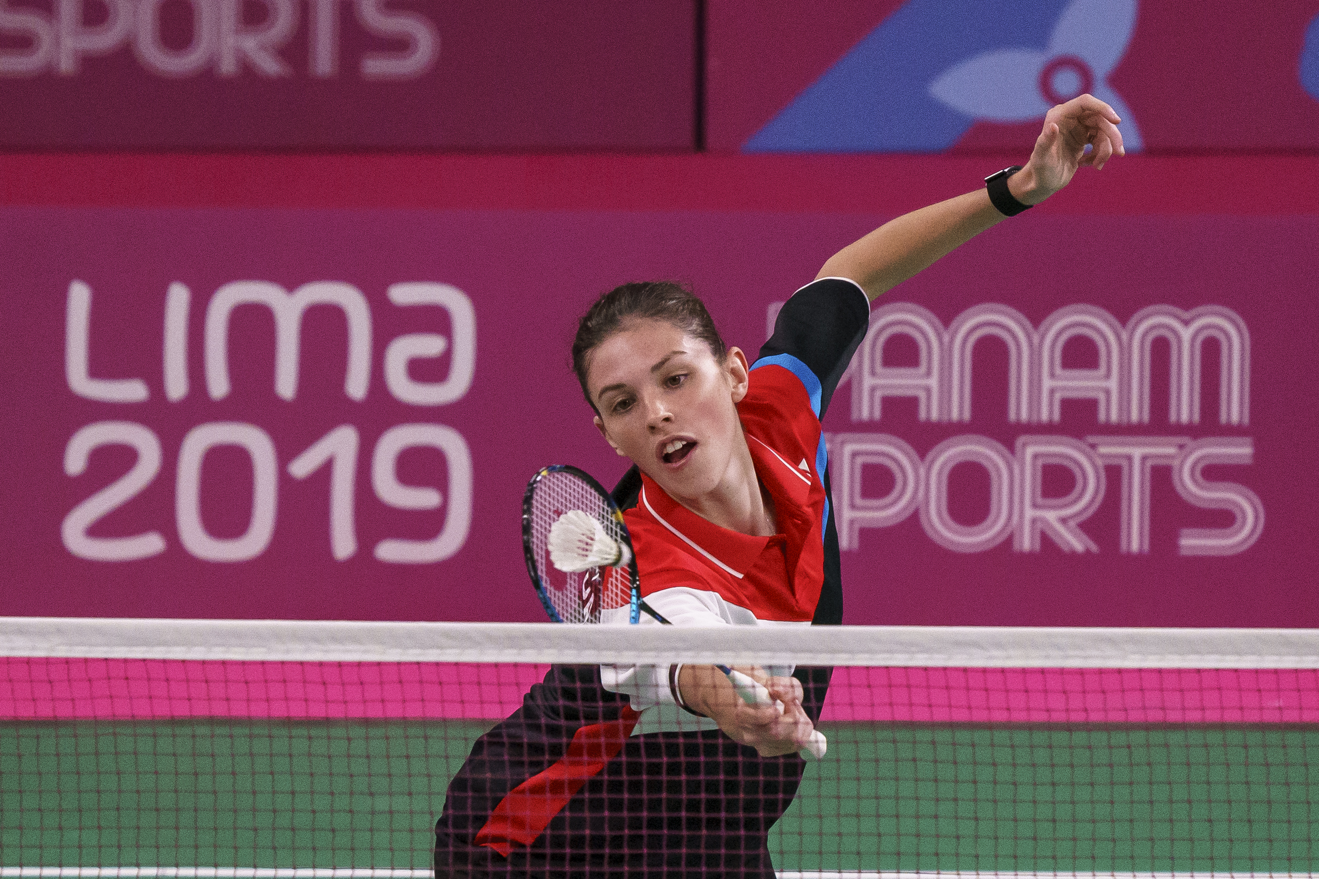 woman reaches for the badminton birdie