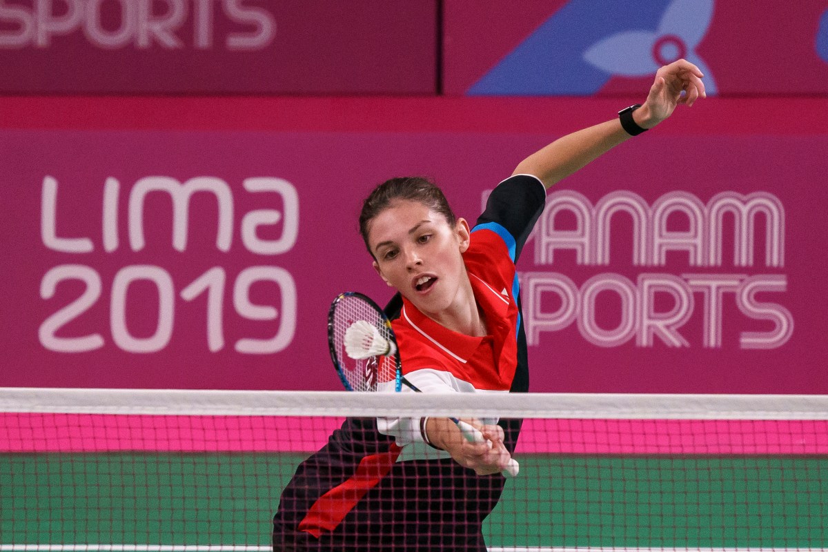 woman reaches for the badminton birdie