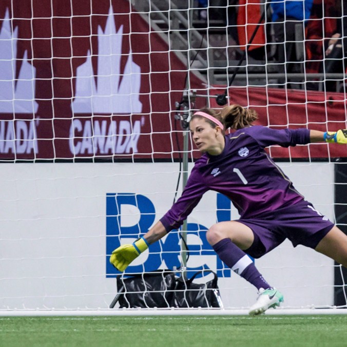 Goalkeeper Stephanie Labbé stretches out to dive for a shot coming her way.