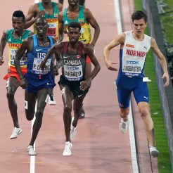 Mohammed Ahmed leads the race against a Norwegian, an American, and three Ethiopians during the 5000 metre race in Doha.