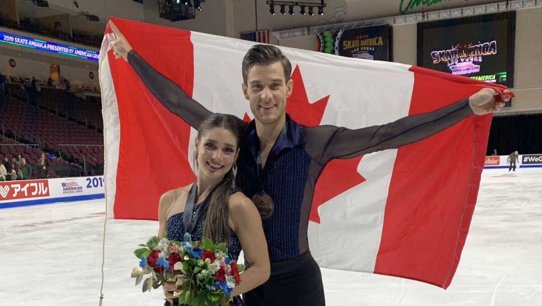 Laurence Fournier Beaudry (front) poses with Nikolaj Sørensen, who is holding the Canadian flag up behind him.