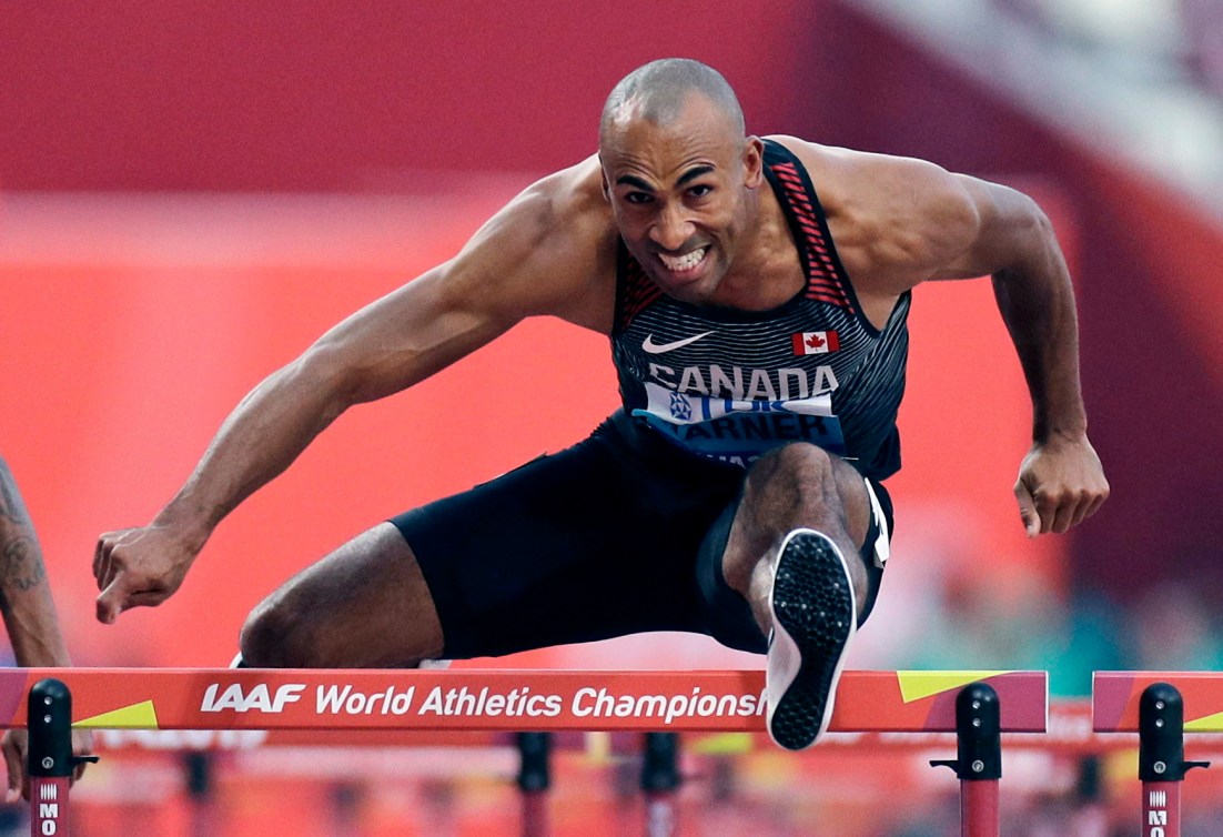 Damian jumps over a hurdle.