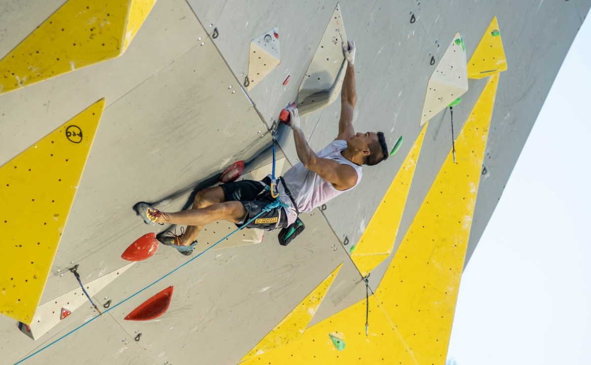 Sean McColl climbs up a wall.
