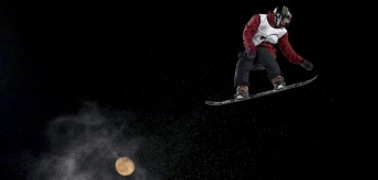 Canada's Darcy Sharpe jumps, backdropped by the moon, in the Men's Snowboard Big Air for the 2019 FIS Big Air World Cup held at the Big Air Shougang in Beijing on Saturday, Dec. 14, 2019. (AP Photo/Ng Han Guan) ///