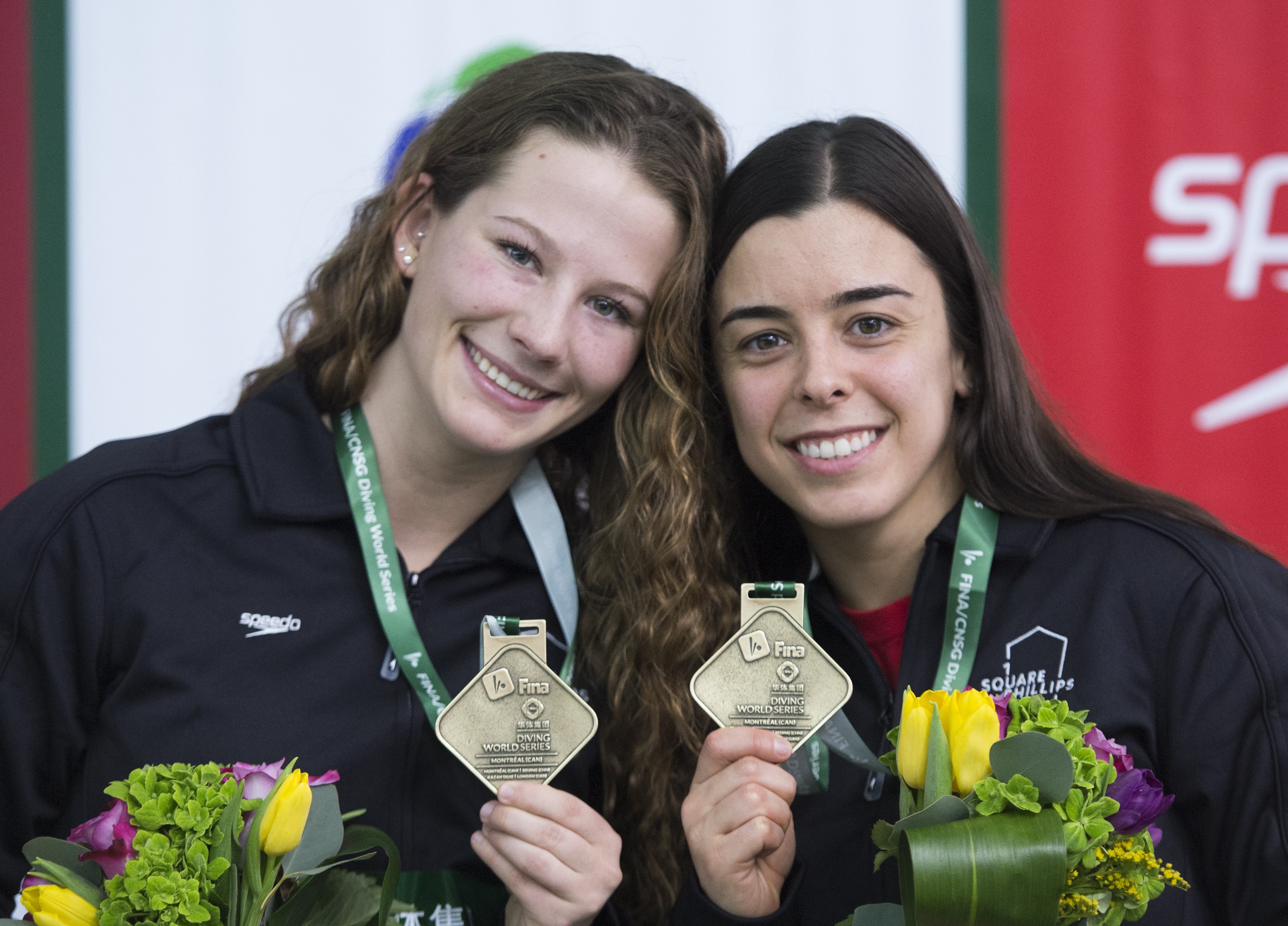 Meaghan Benfeito, right, and Caeli McKay of Canada hold up their gold medals after winning the women's 10-metre platform synchro final.