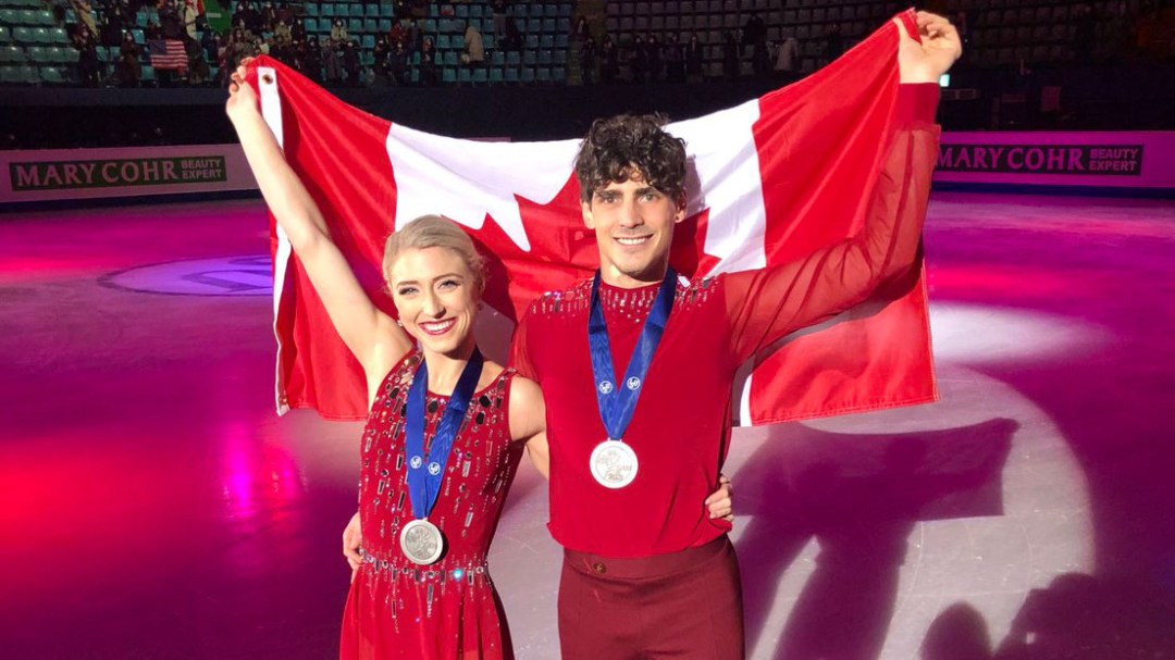 Piper Gilles (left) and Paul Poirier pose for a photo with their medals and the Team Canada flag.