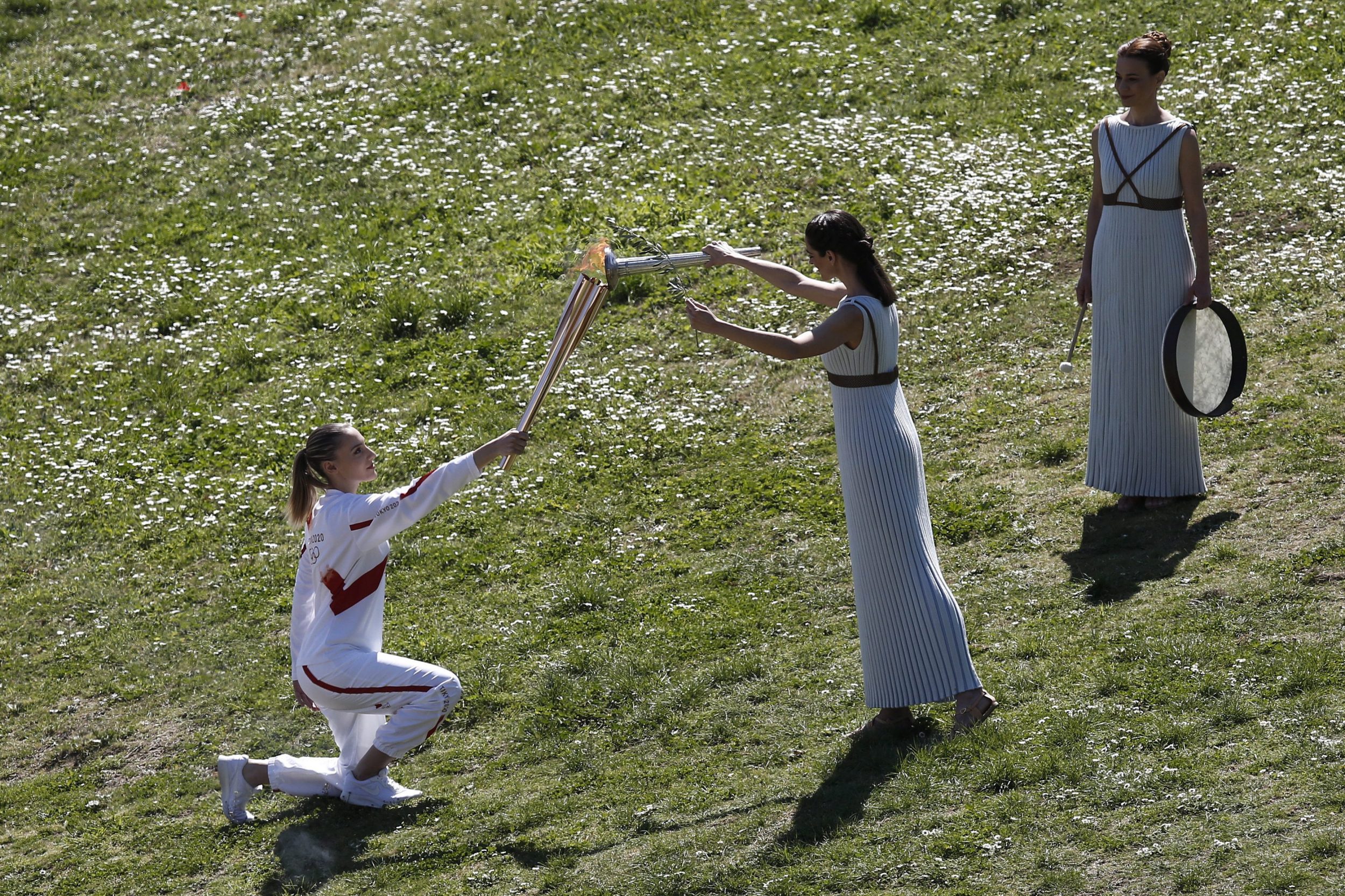 The Olympic flame lights the Tokyo 2020 torch for the first time in Olympia