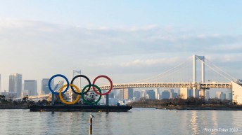 Olympic rings in front of a Tokyo bridge