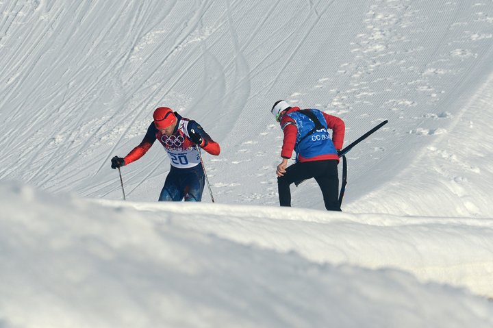 coach helping skiier